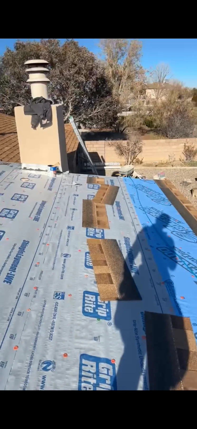 Roofing installation in progress with underlayment and shingles